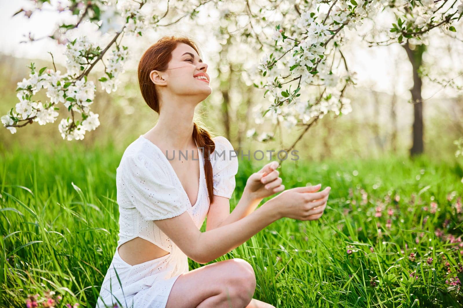 beautiful young readhead woman standing near the apple tree. High quality photo