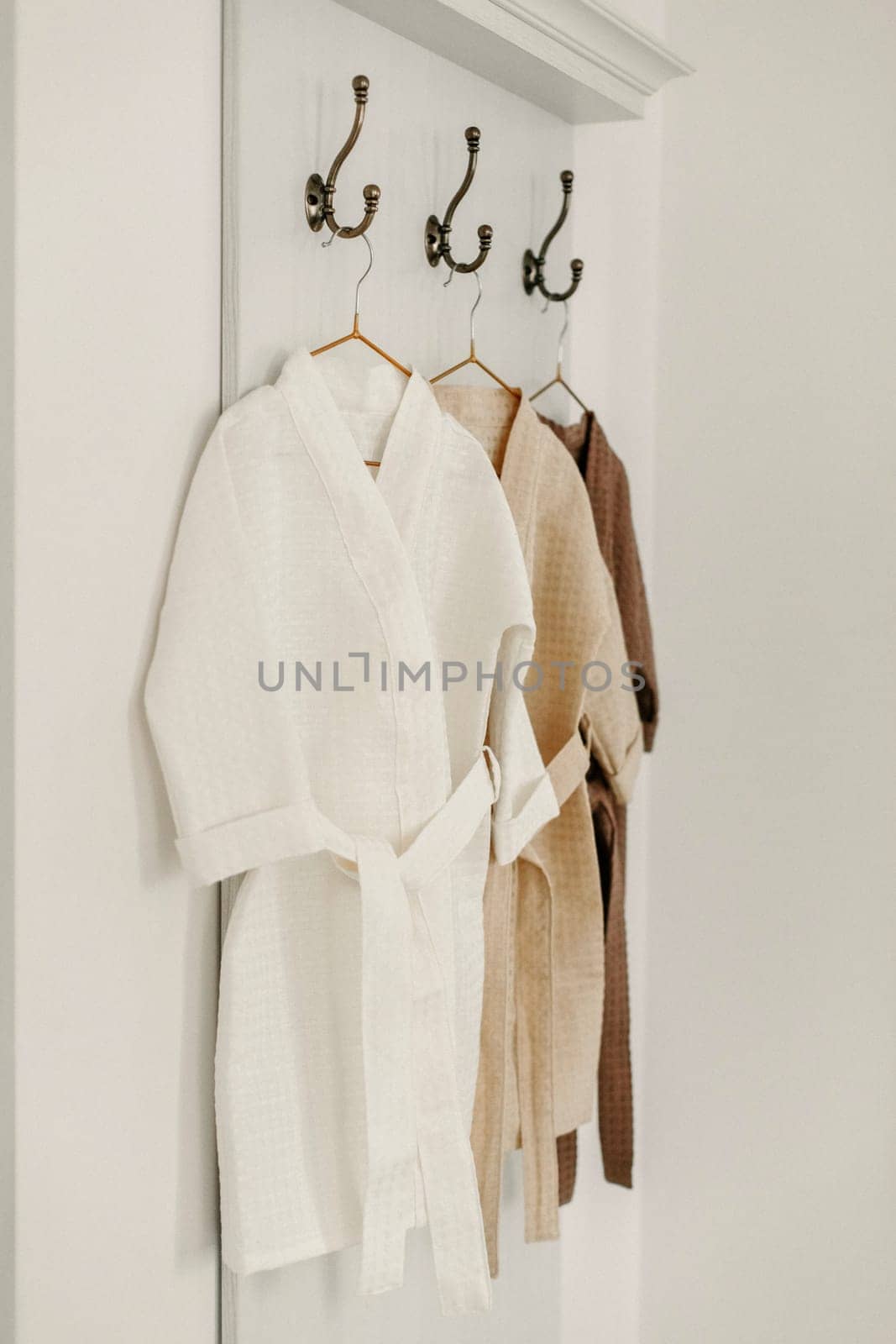 Linen bathrobes hang on a hanger in the bathroom by Sd28DimoN_1976
