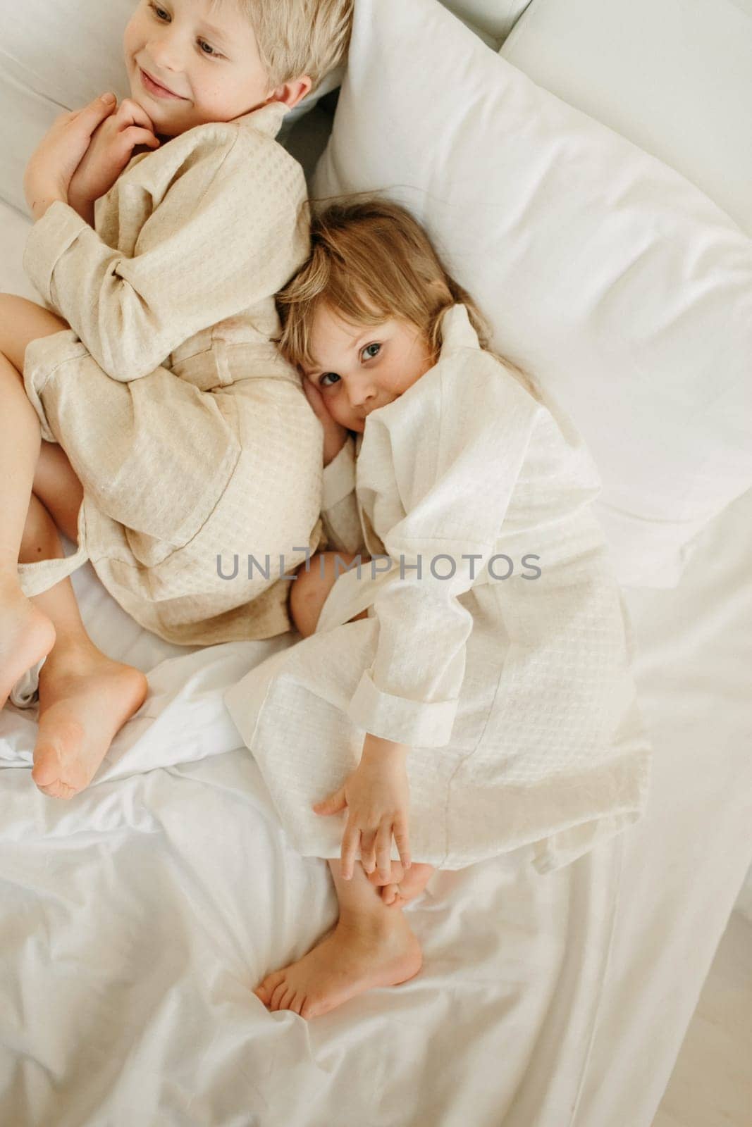 The brothers lie on the bed in bathrobes after a shower.