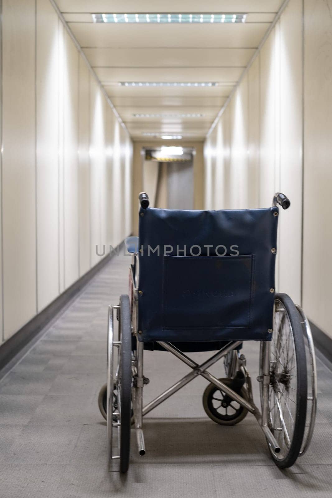 Empty wheelchair in aerobridge, empty wheelchair in walkway, empty wheelchair in airport. High quality photo