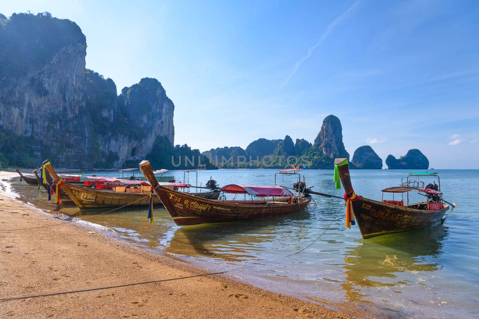 KRABI, THAILAND- MARCH 2018: Long tail boat on tropical beach with palms, Tonsai Bay, Railay Beach, Ao Nang, Krabi, Thailand.