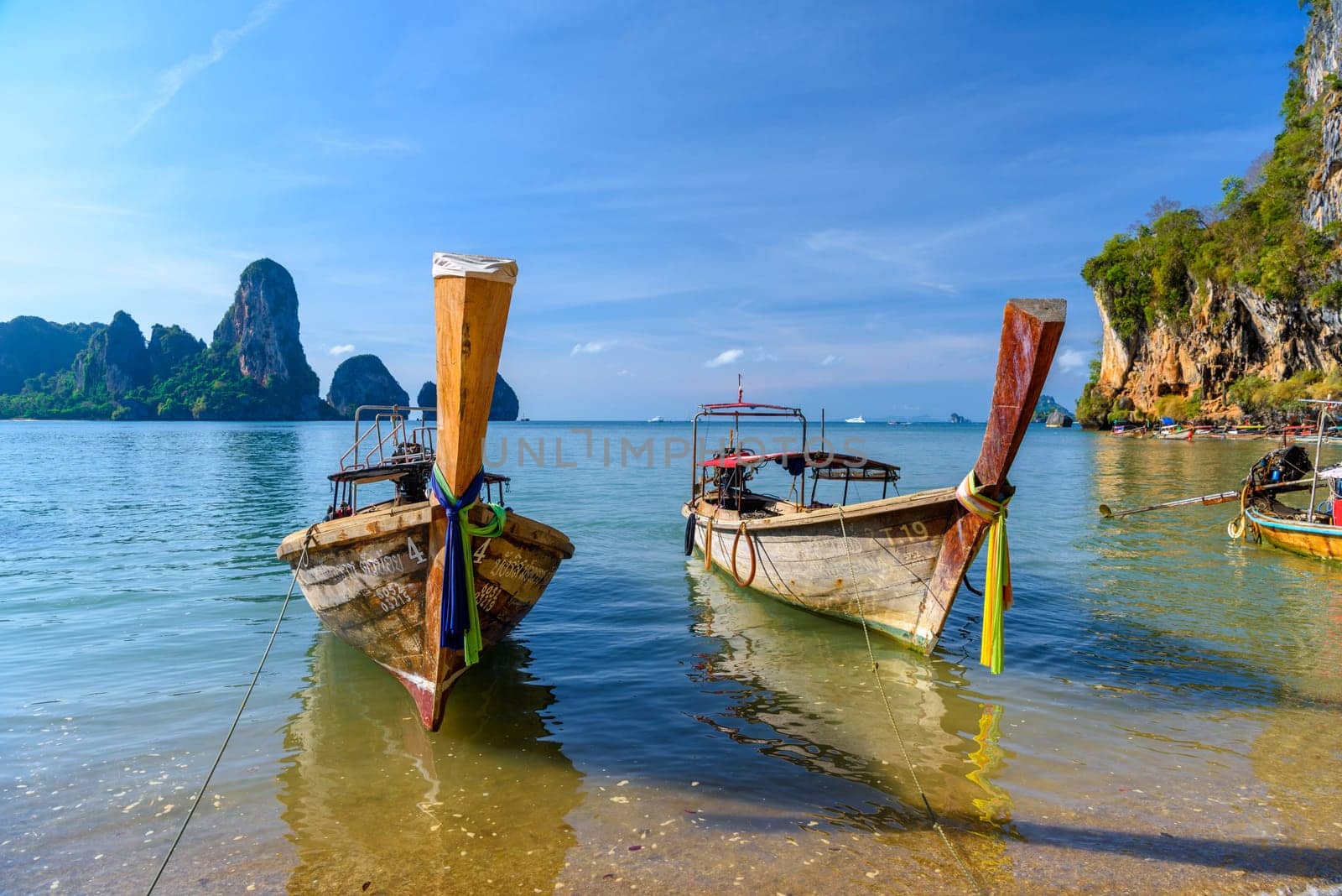 KRABI, THAILAND- MARCH 2018: Long tail boat on tropical beach with palms, Tonsai Bay, Railay Beach, Ao Nang, Krabi, Thailand by Eagle2308