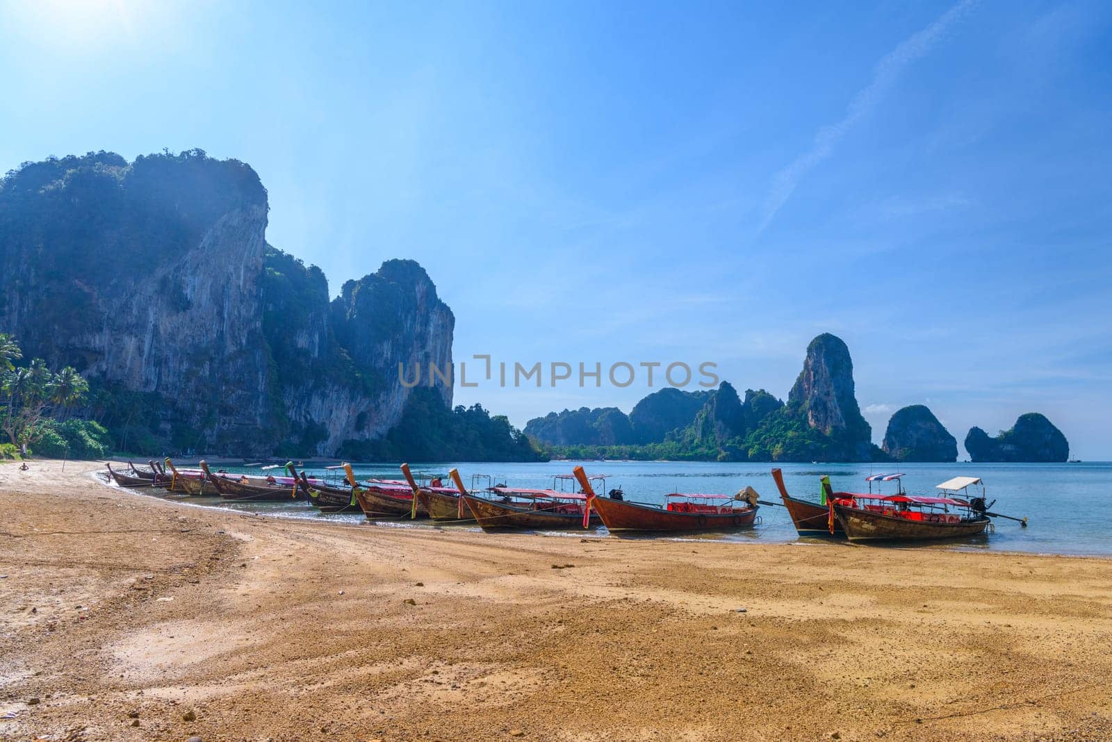KRABI, THAILAND- MARCH 2018: Long tail boat on tropical beach with palms, Tonsai Bay, Railay Beach, Ao Nang, Krabi, Thailand.