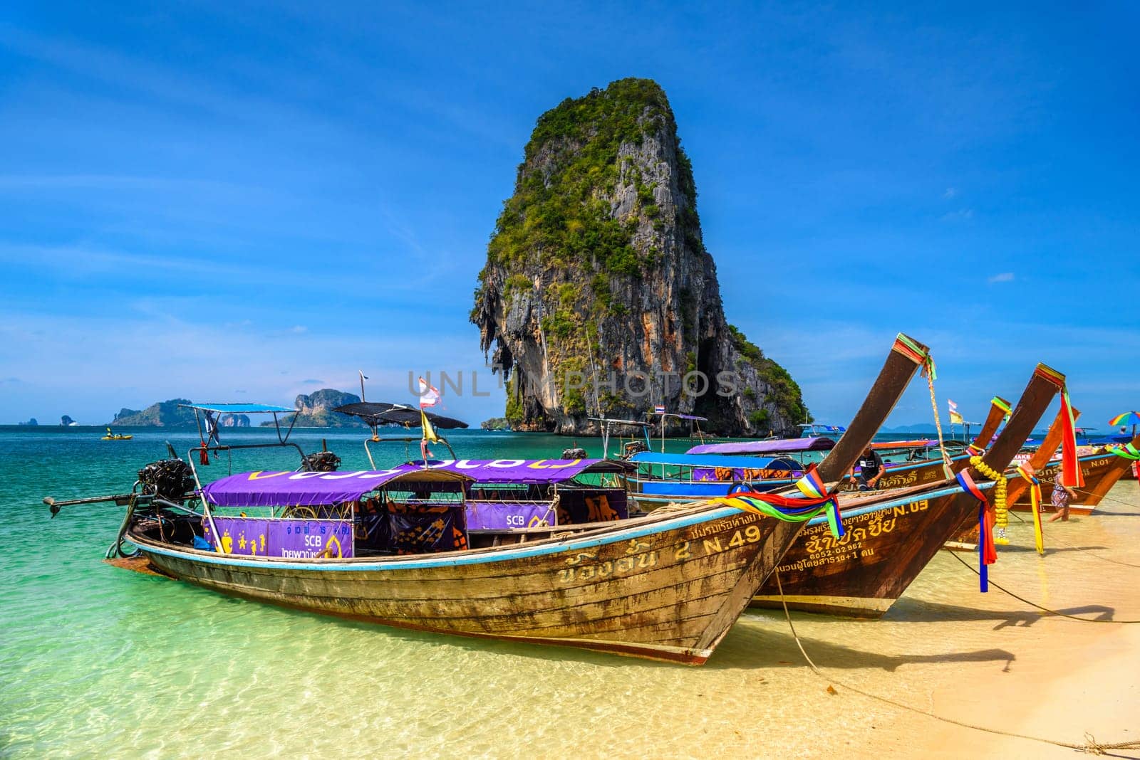 KRABI, THAILAND- MARCH 2018: Long tail boats and cliff rock in azure water, Ko Rang Nok, Ao Phra Nang Beach, Ao Nang, Krabi, Thailand.