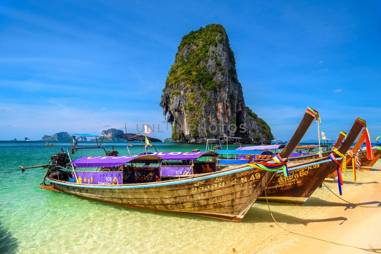 KRABI, THAILAND- MARCH 2018: Long tail boats and cliff rock in azure water, Ko Rang Nok, Ao Phra Nang Beach, Ao Nang, Krabi, Thailand by Eagle2308