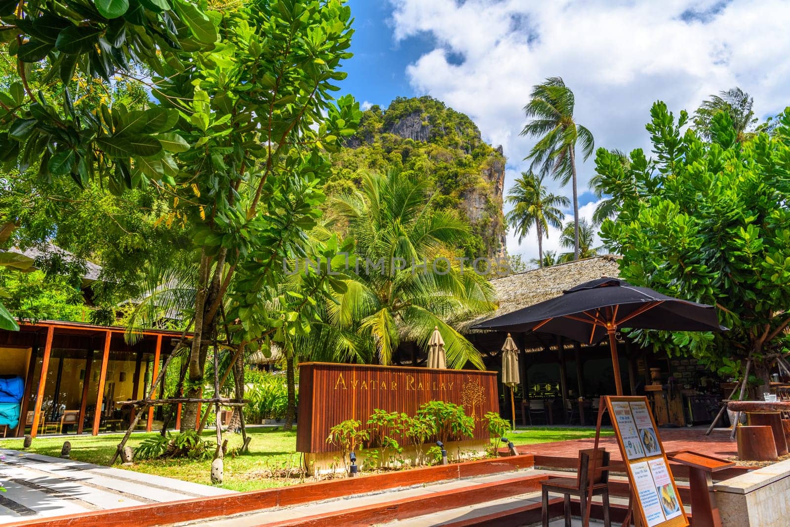 KRABI, THAILAND- MARCH 2018: Palms and bungalows houses near the cliffs on Ao Phra Nang Beach, Railay east Ao Nang, Krabi, Thailand.