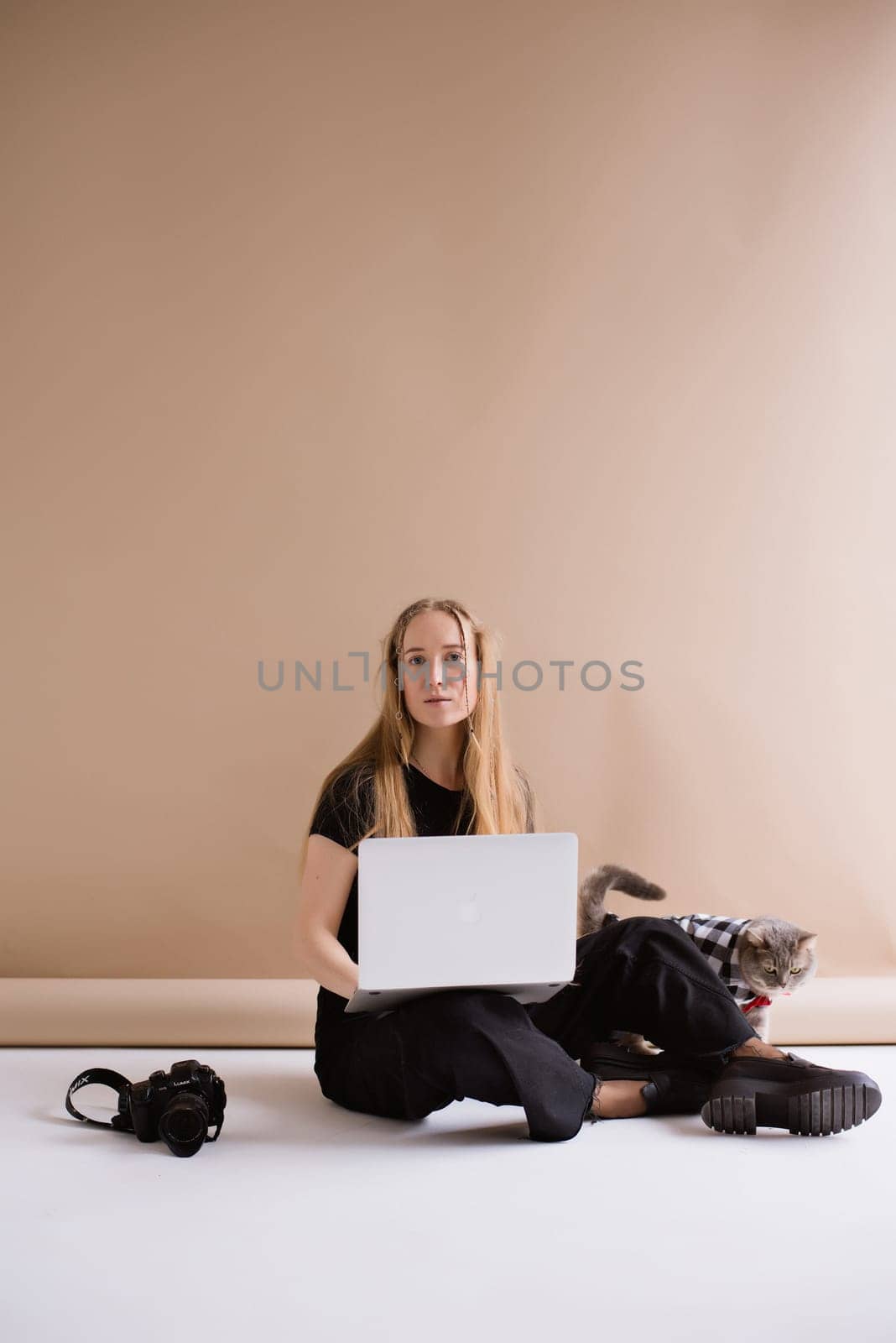 Woman freelancer typing to MacBook in photo studio by OksanaFedorchuk