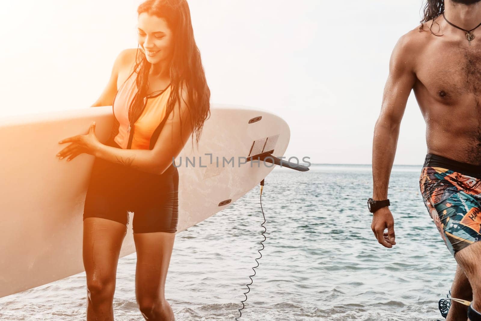 Sea woman and man on sup. Silhouette of happy young woman and man, surfing on SUP board, confident paddling through water surface. Idyllic sunset. Active lifestyle at sea or river