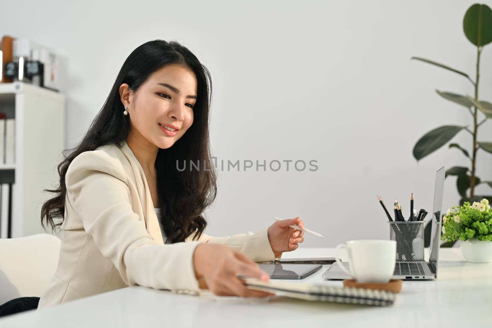 Charming asian woman working on online marketing, using laptop computer at workplace.