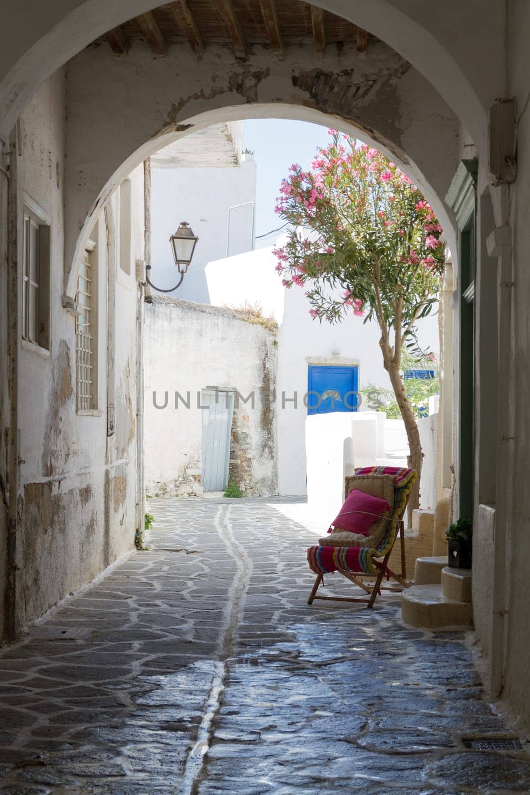 Classical narrow street with a painted sidewalk in Parikia