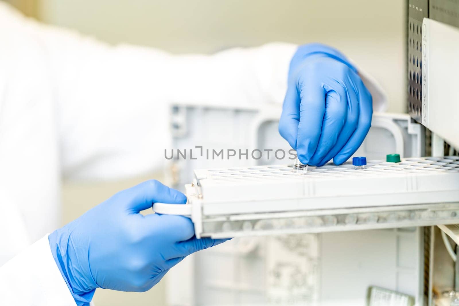 conducting chemical experiments in modern devices in a research laboratory. inserting the container with the solution into the measuring device.