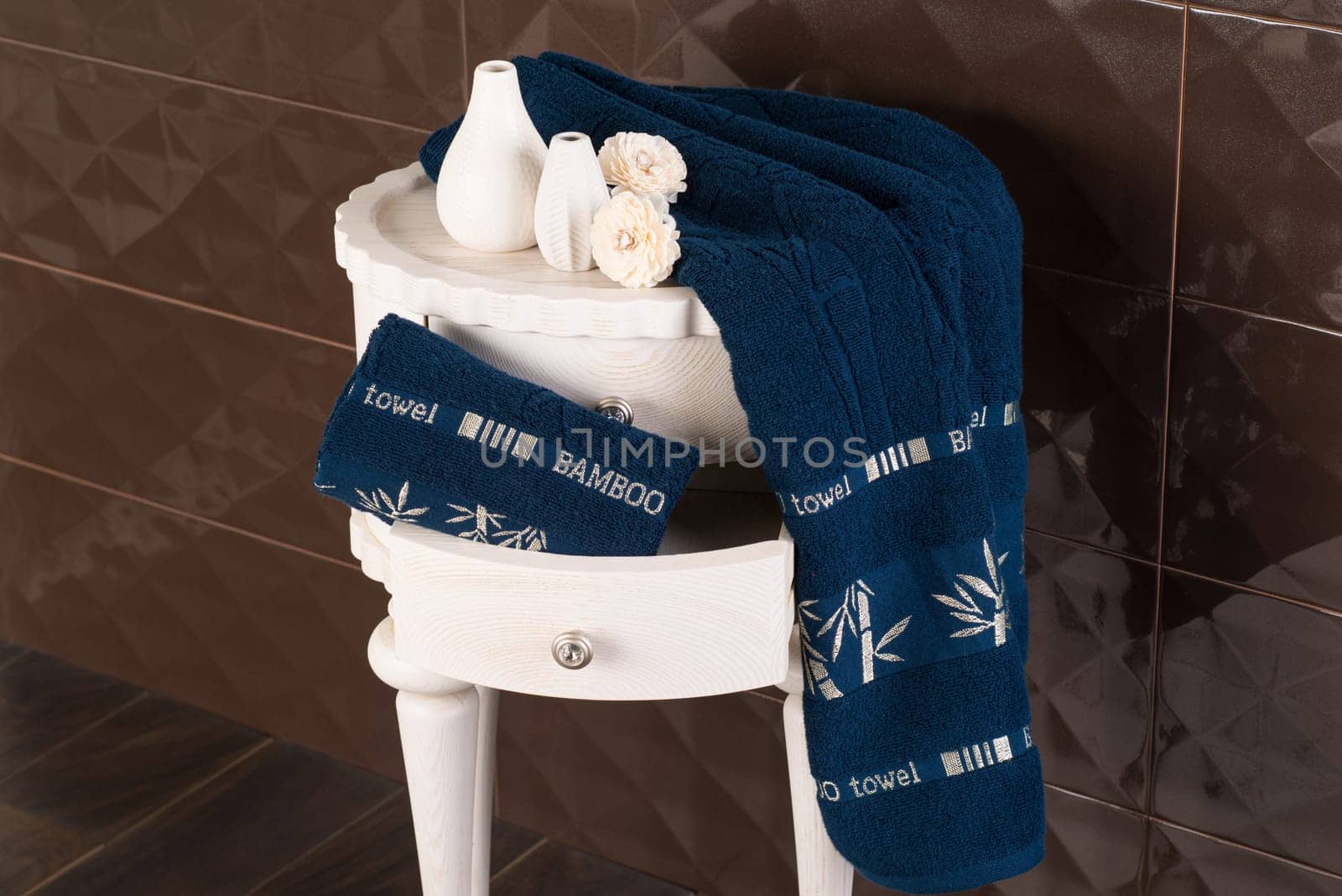 A closeup shot of a bathroom cabine with a drawer with navy blue bamboo towels by A_Karim