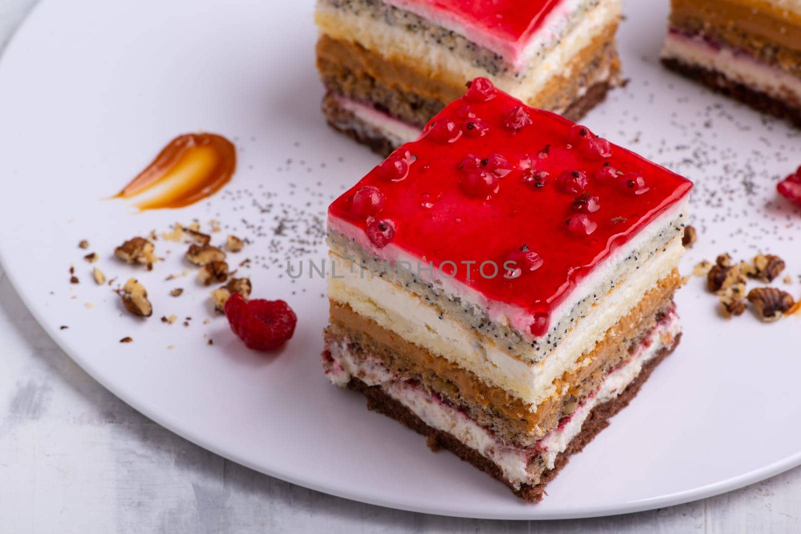An appetizing dessert with slices of cakes with raspberry and nuts by A_Karim