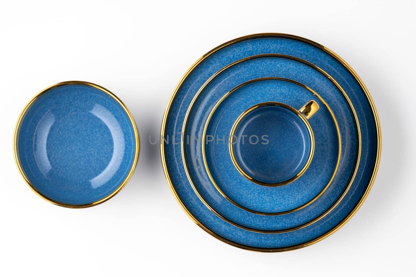 A set of blue ceramic plates and cup on a white background. Top view