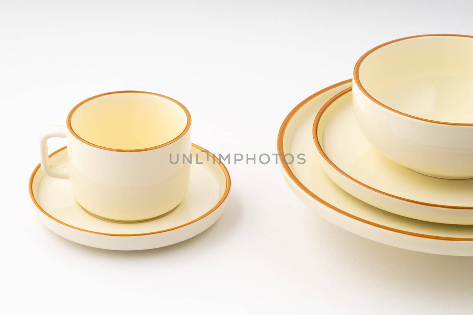 A set of white and brown ceramic plate and cup on a white background