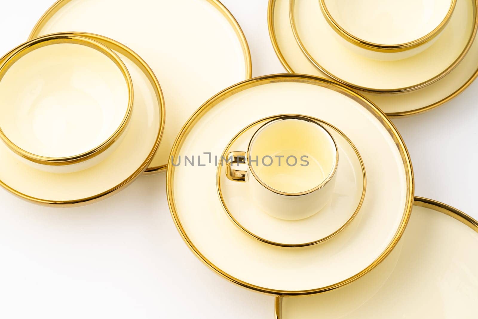 A set of golden luxury ceramic kitchen utensils on a white background