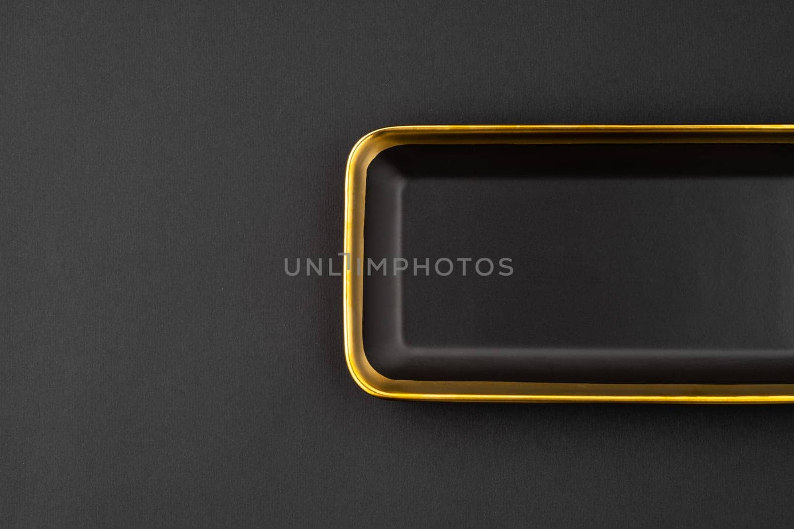 A set of black and golden ceramic plate on a black background. Top view by A_Karim