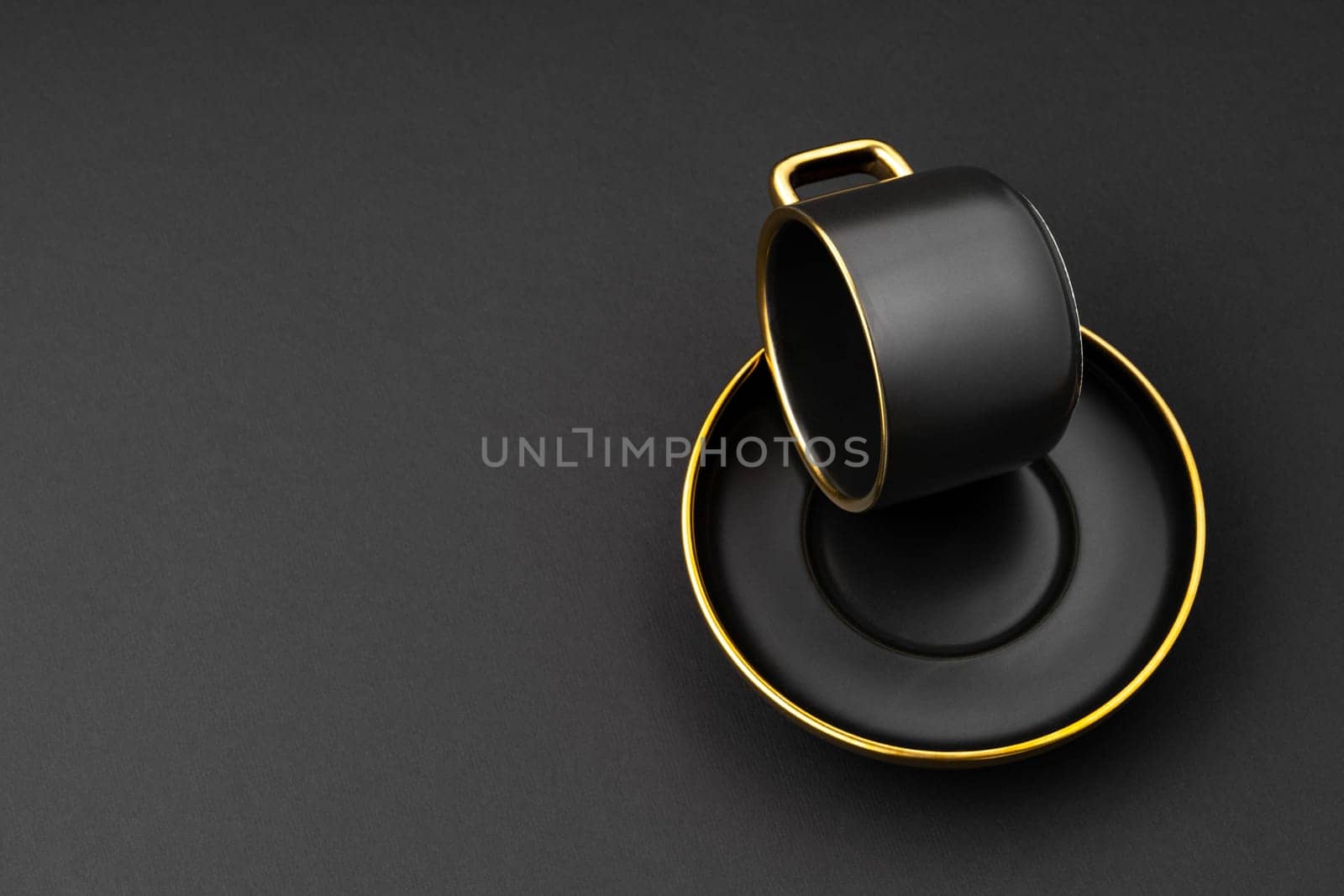 A set of black and golden ceramic plates and cup on a black background by A_Karim