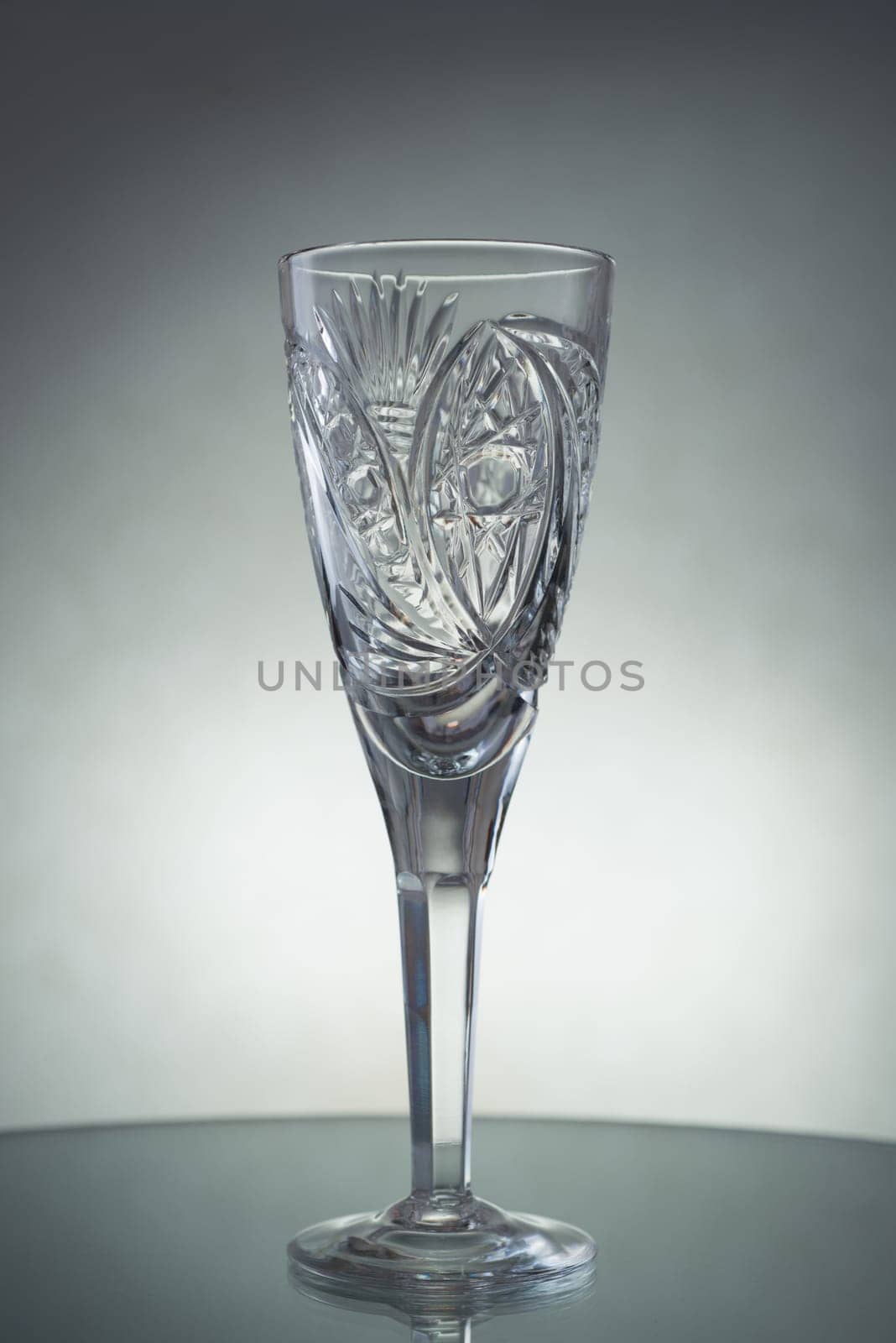 A vertical shot of an empty champagne glass on a grey background