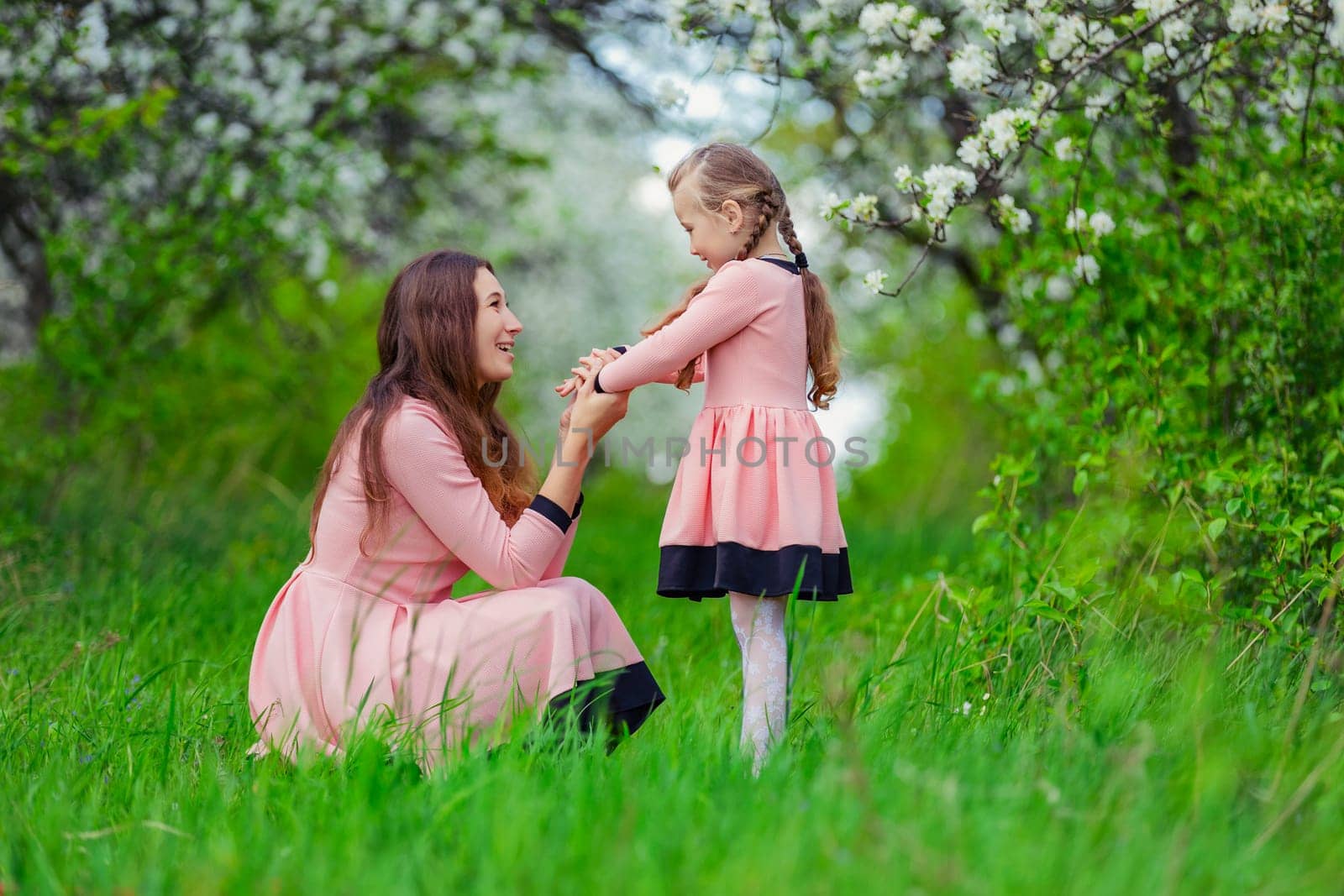 mother and daughter in nature in identical dresses