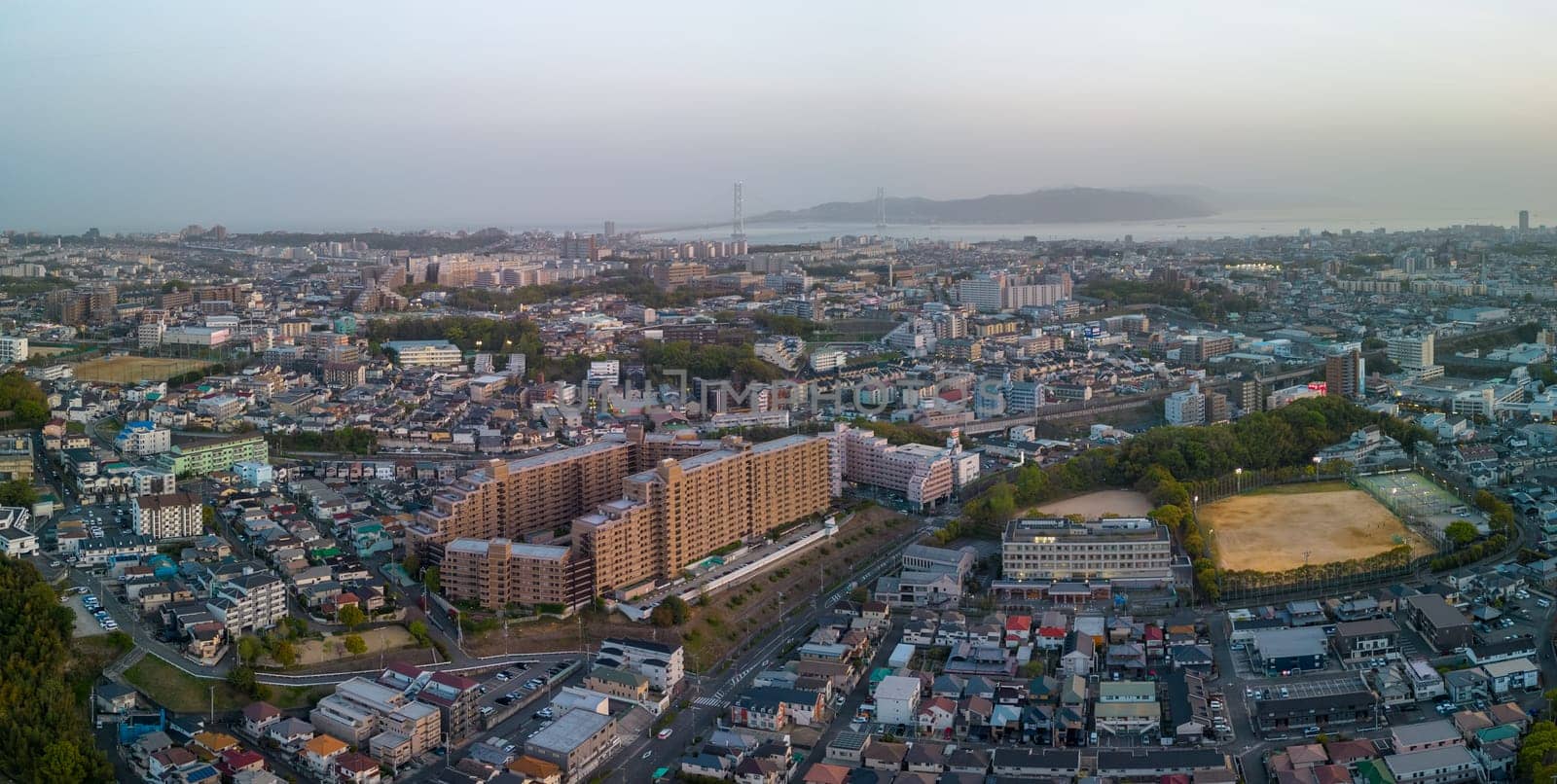 Aerial view of Akashi City buildings and bridge to Awaji Island at sunset. High quality photo