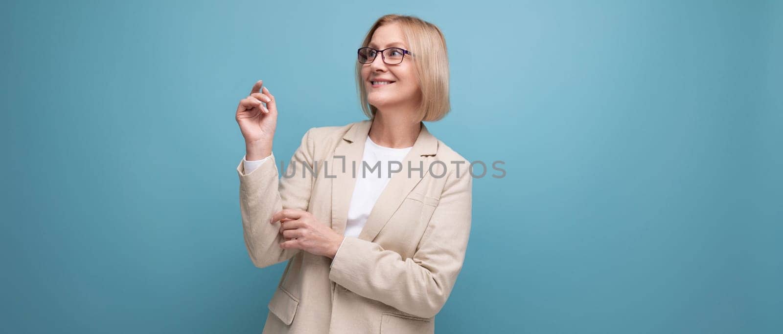 energetic mature woman in stylish jacket on bright studio background with copy space.
