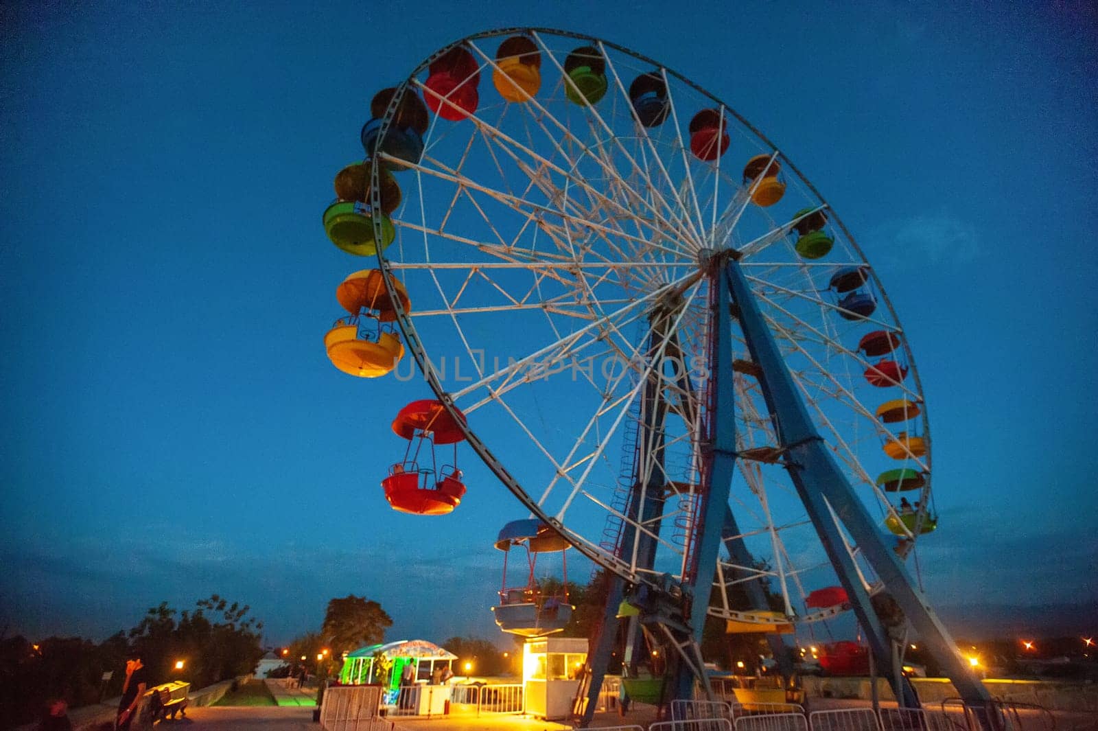 A attraction ferris wheel in the amusement park at night by A_Karim