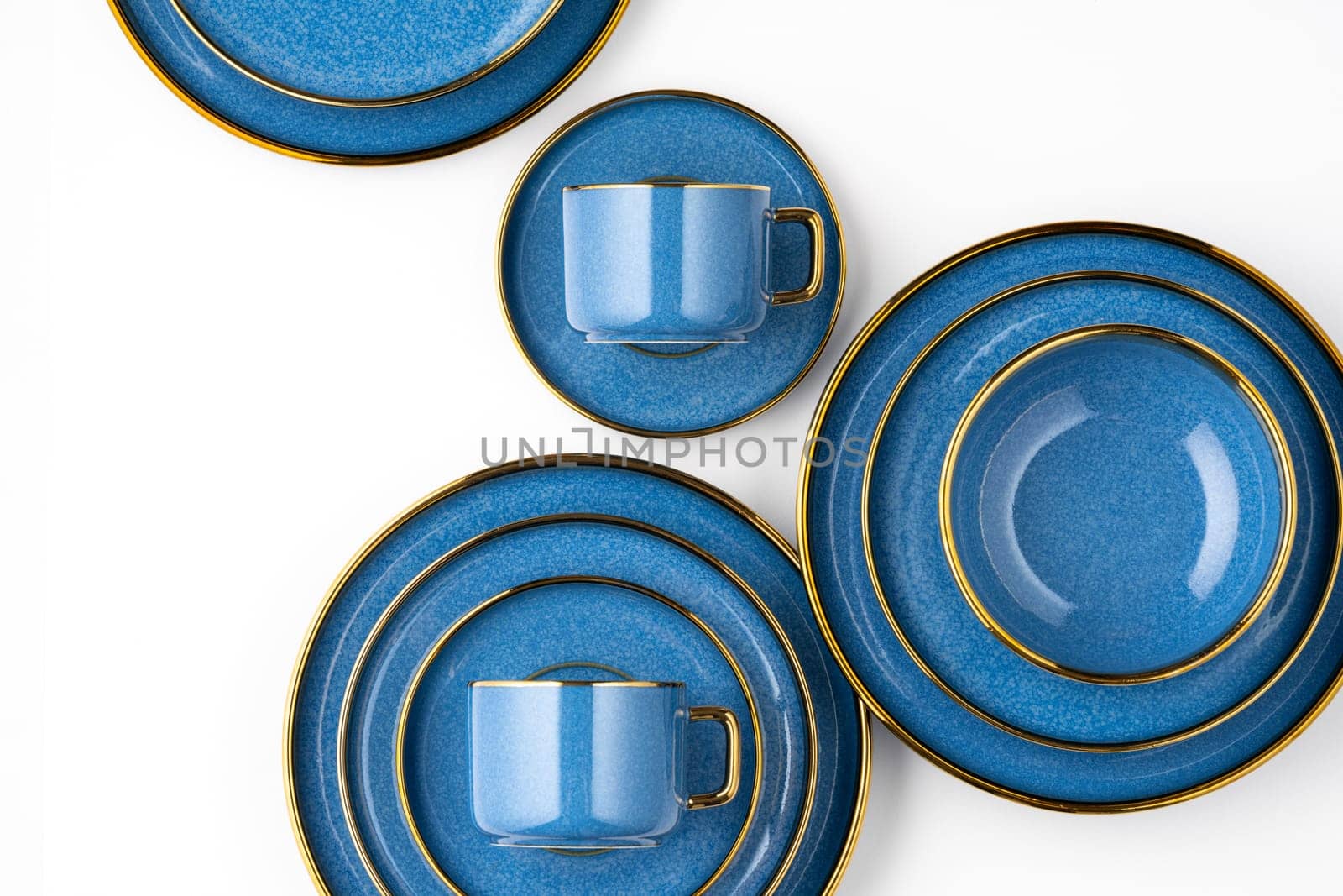 A set of blue ceramic plates and cup on a white background. Top view by A_Karim