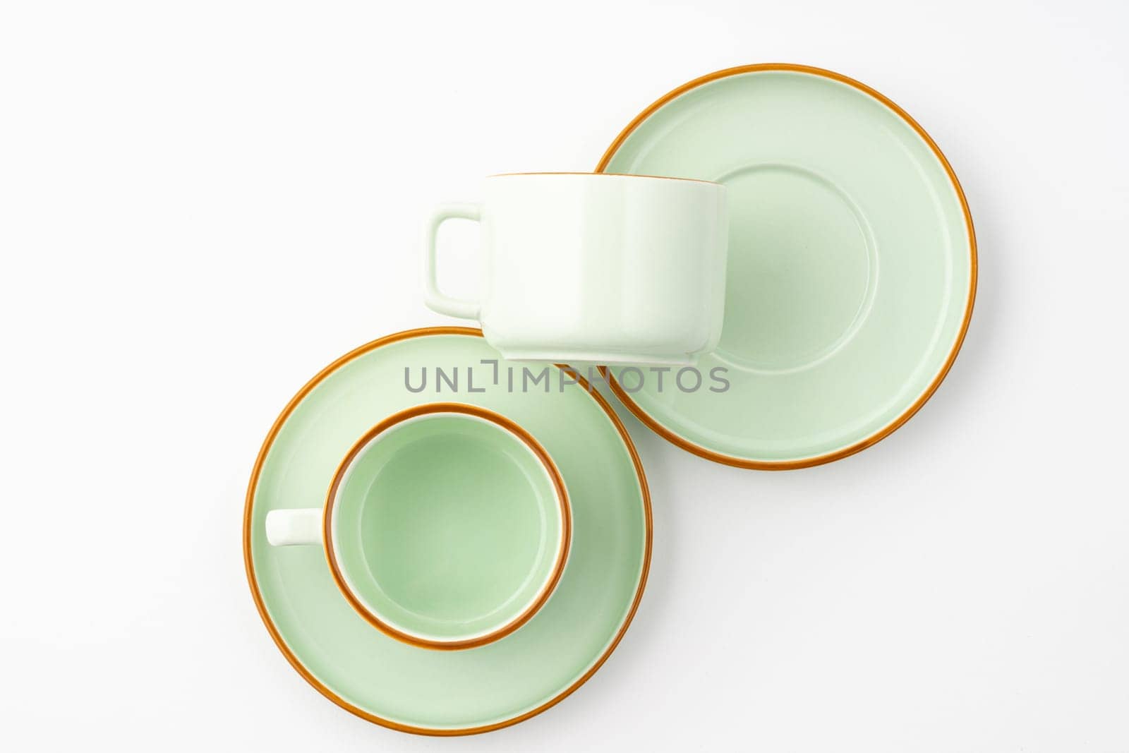 A flat lay of a set of ceramic kitchen utensils such as cups and plates on white background by A_Karim