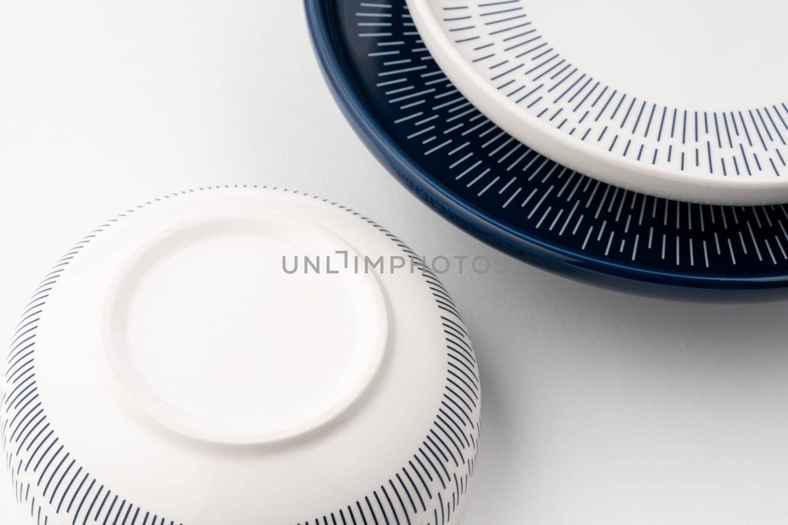 A closeup shot of a blue and white mug on a saucer with a white background