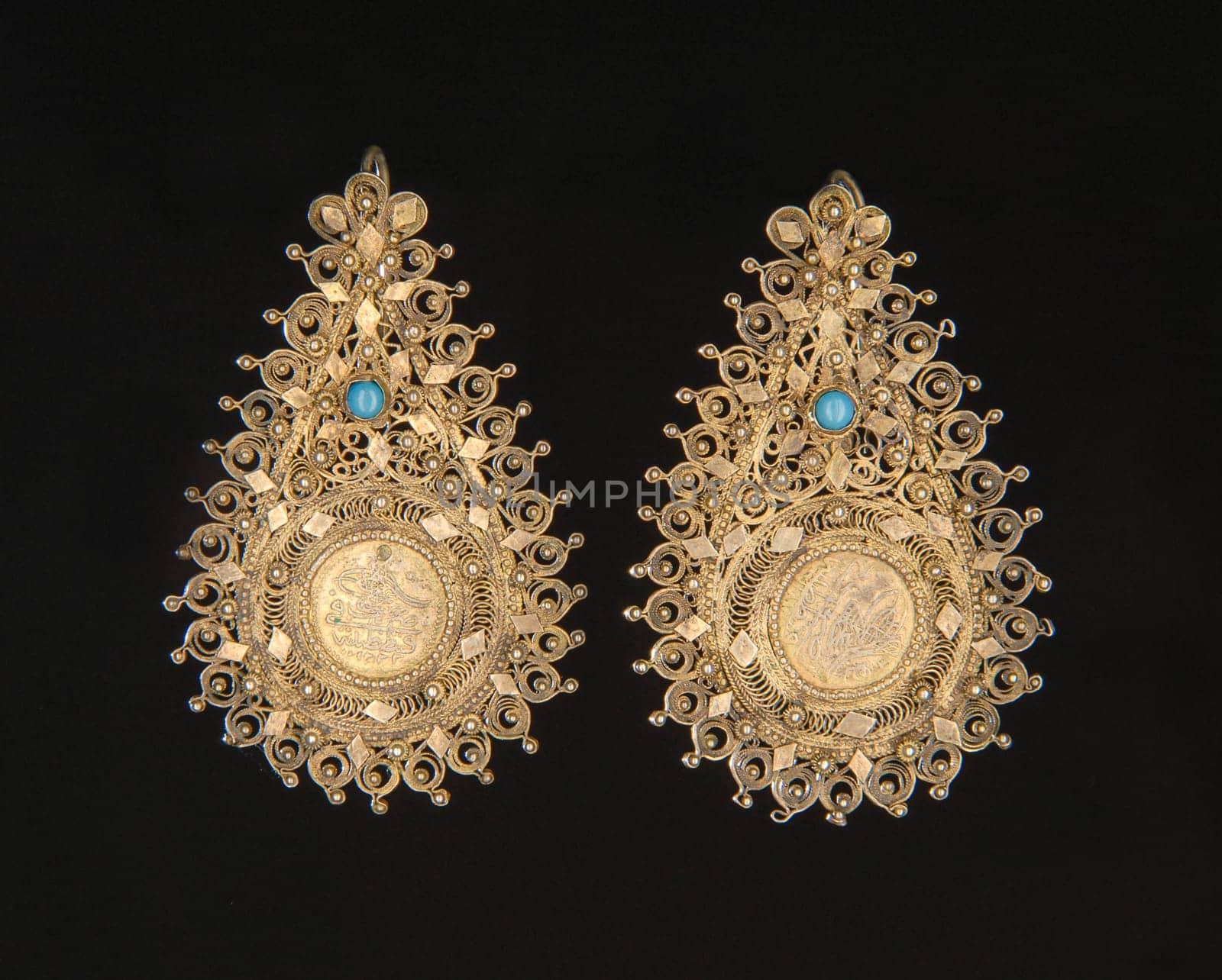 The vintage, central Asian earrings with precious stones isolated on a black background by A_Karim