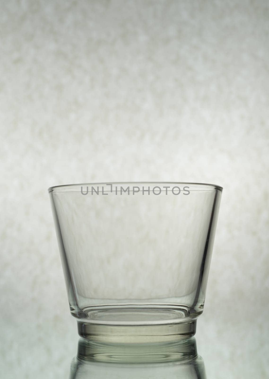 A vertical shot of an empty glass on a grey background by A_Karim