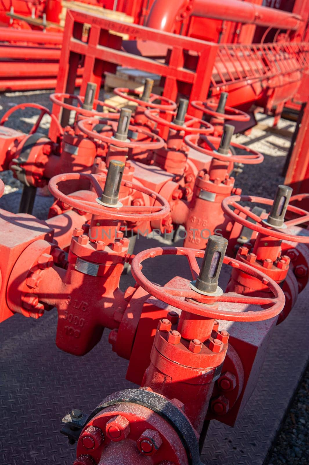 A closeup of a red industrial oil pipeline valves