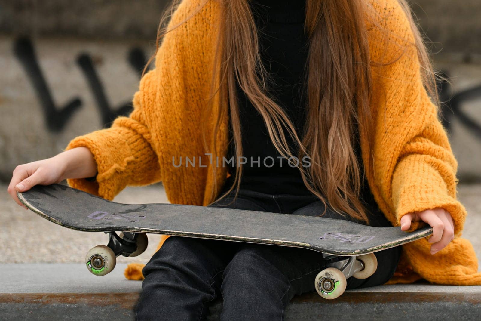 A girl with a skateboard in the city