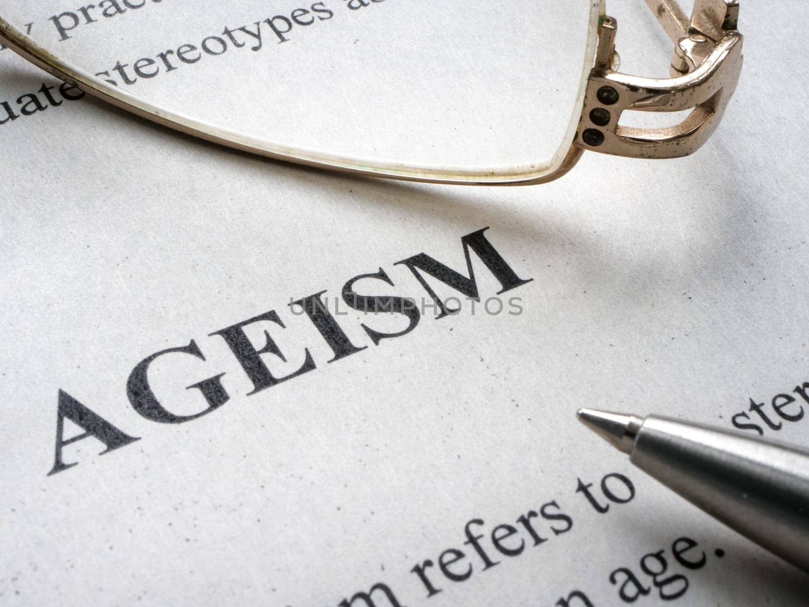 Close-up of the word Ageism and glasses nearby. by designer491