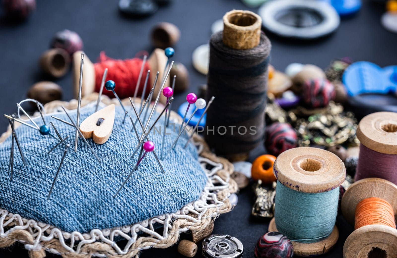 Close up of sewing pins, retro threads and beads assortment