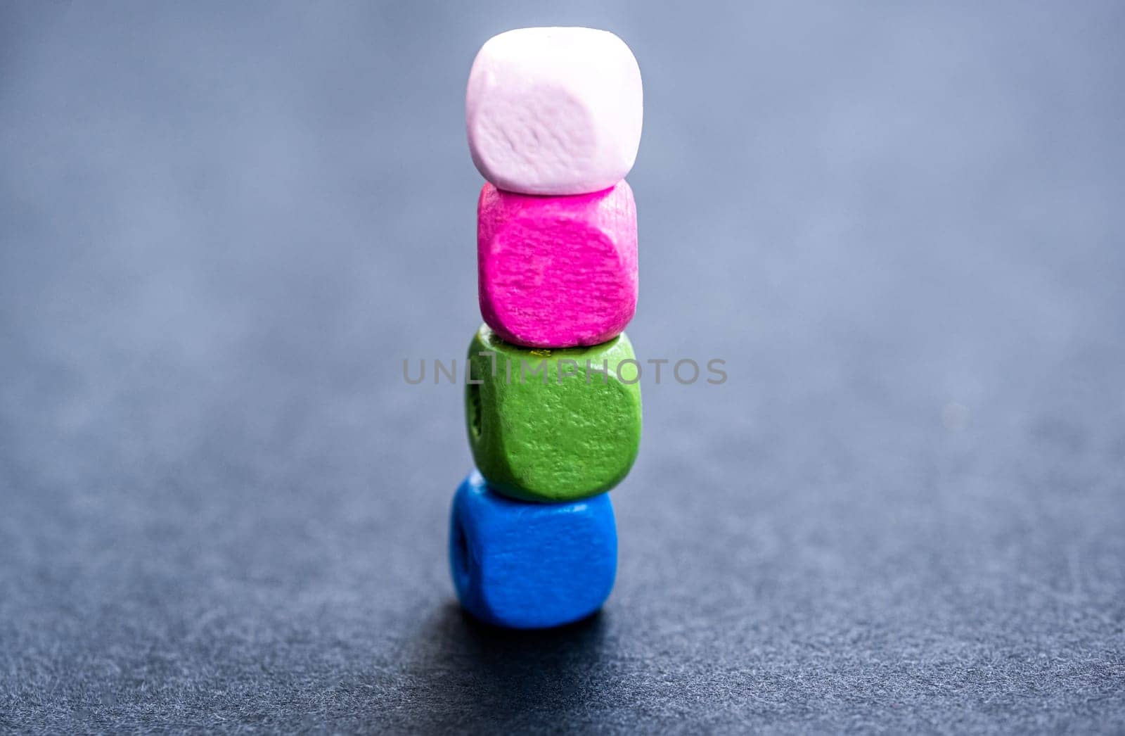 Stack of bright wooden beads on gray background