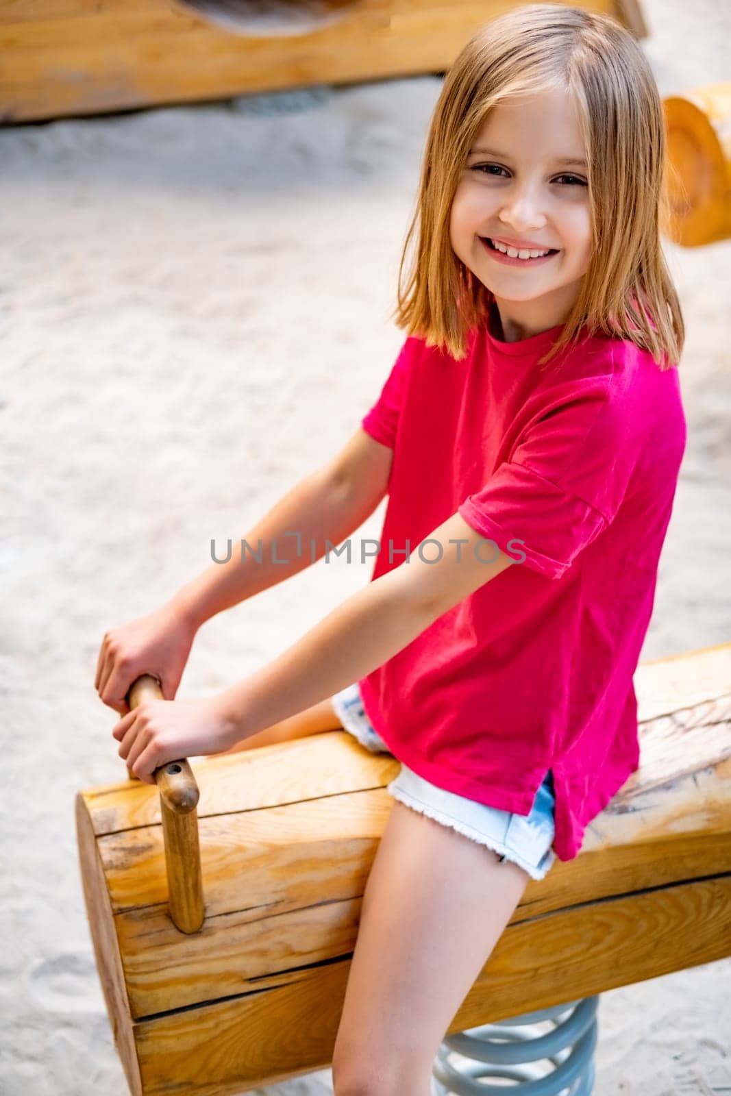 Little girl riding swing on playground by GekaSkr