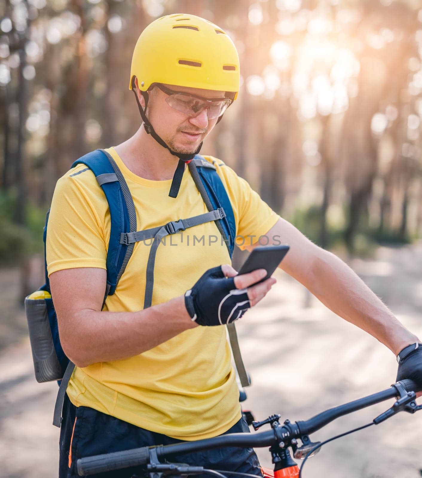 Man using smartphone with map during cycling by GekaSkr