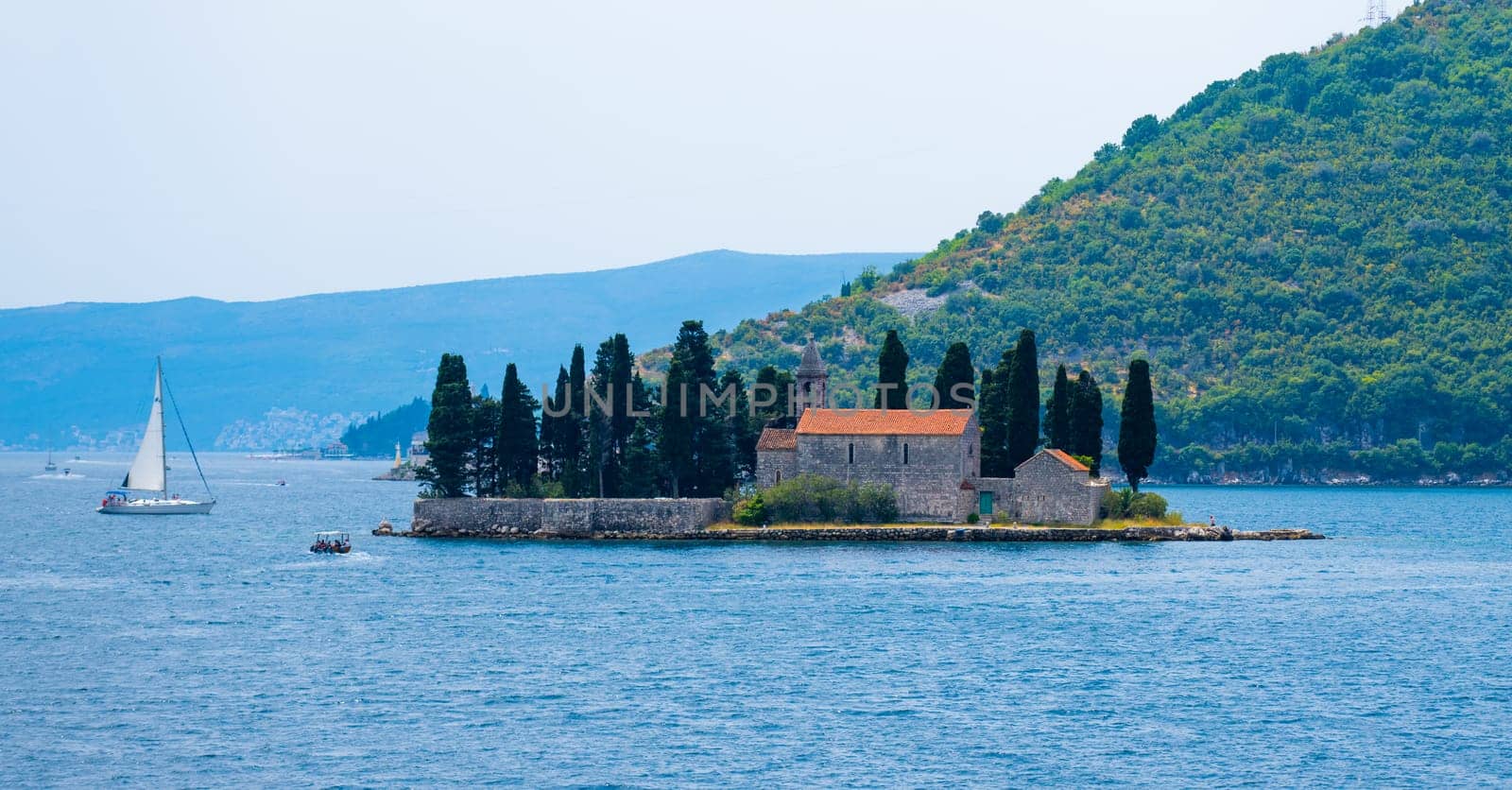 Island Lady of the Rocks in Montenegro in Kotor bay with mountains view. Ancient architecture in Adriatic sea