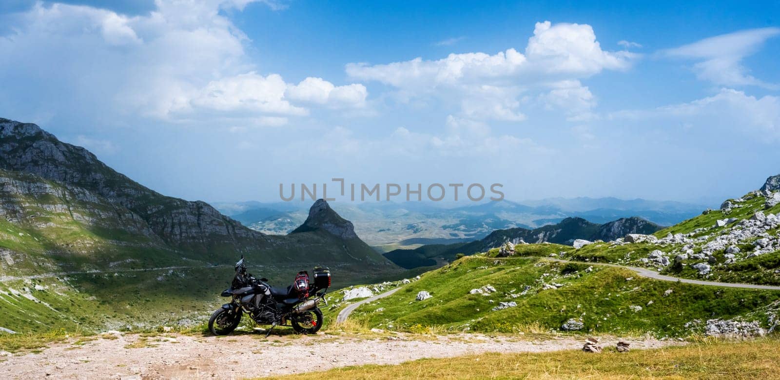 Motocycle standing in the mountain pick in National park Durmitor in Montenegro with amazing nature landscape view