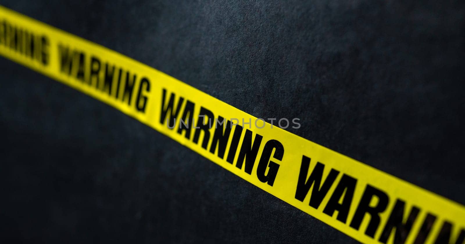 Yellow caution tape stripe with words warning. Concept of danger, security and protection. Symbol of risk and forbidden actions