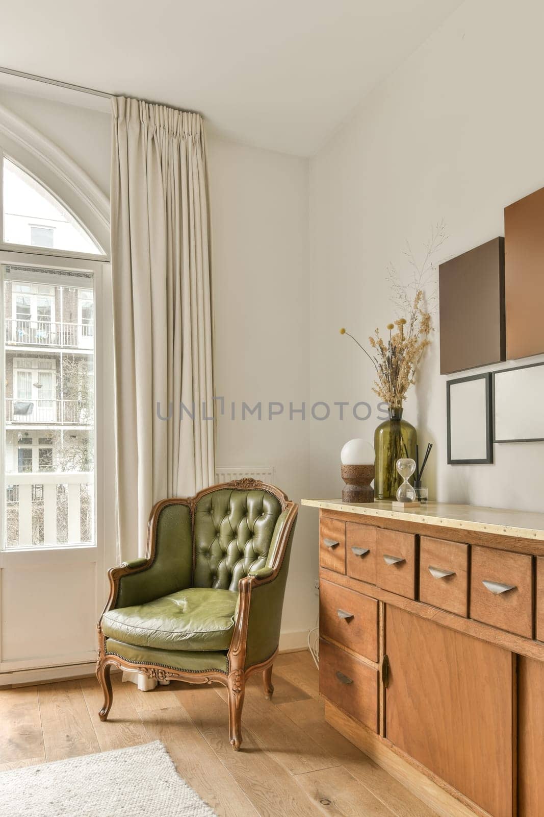 a corner of a living room with a green chair by casamedia