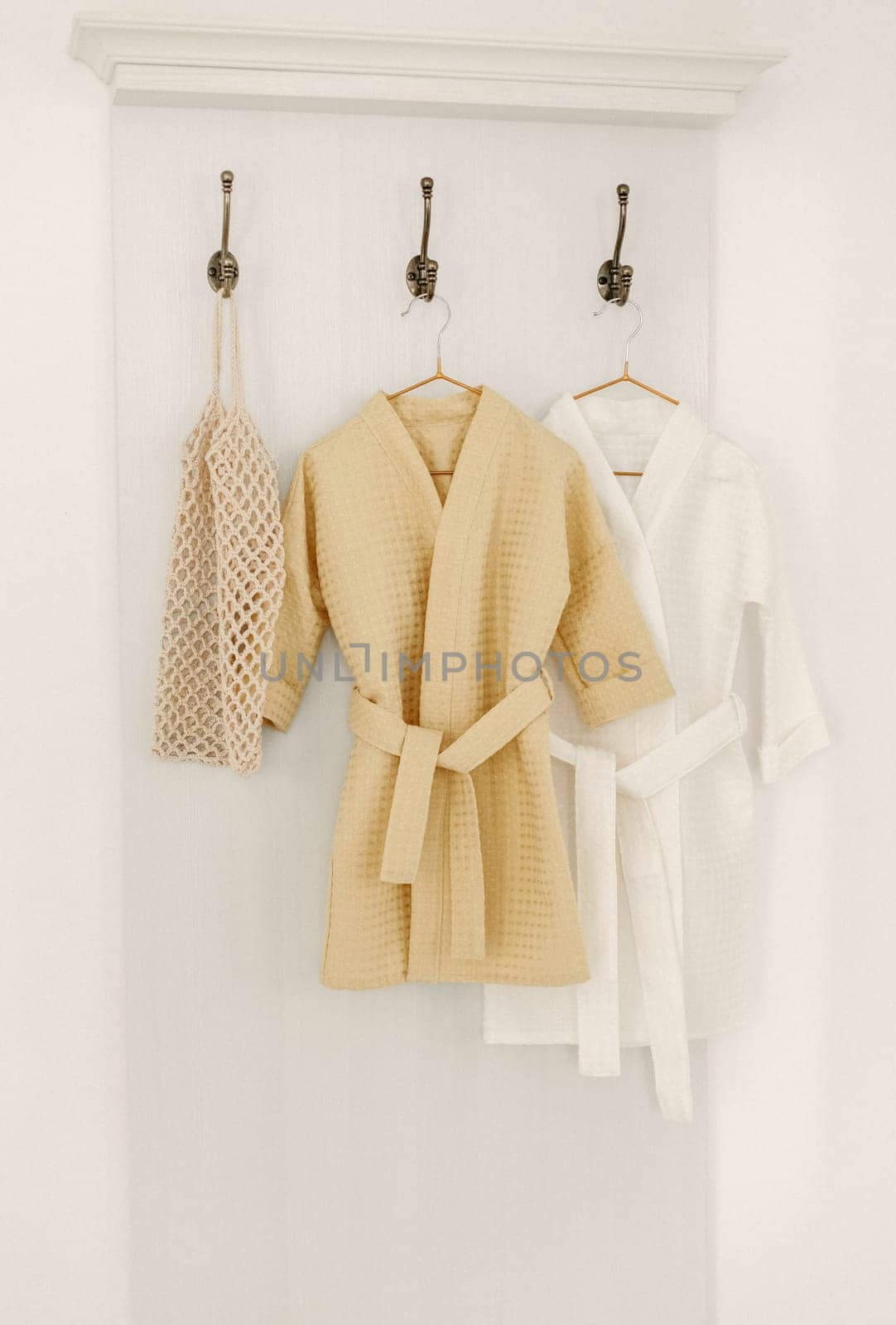 Linen bathrobes hang on a hanger in the bathroom by Sd28DimoN_1976