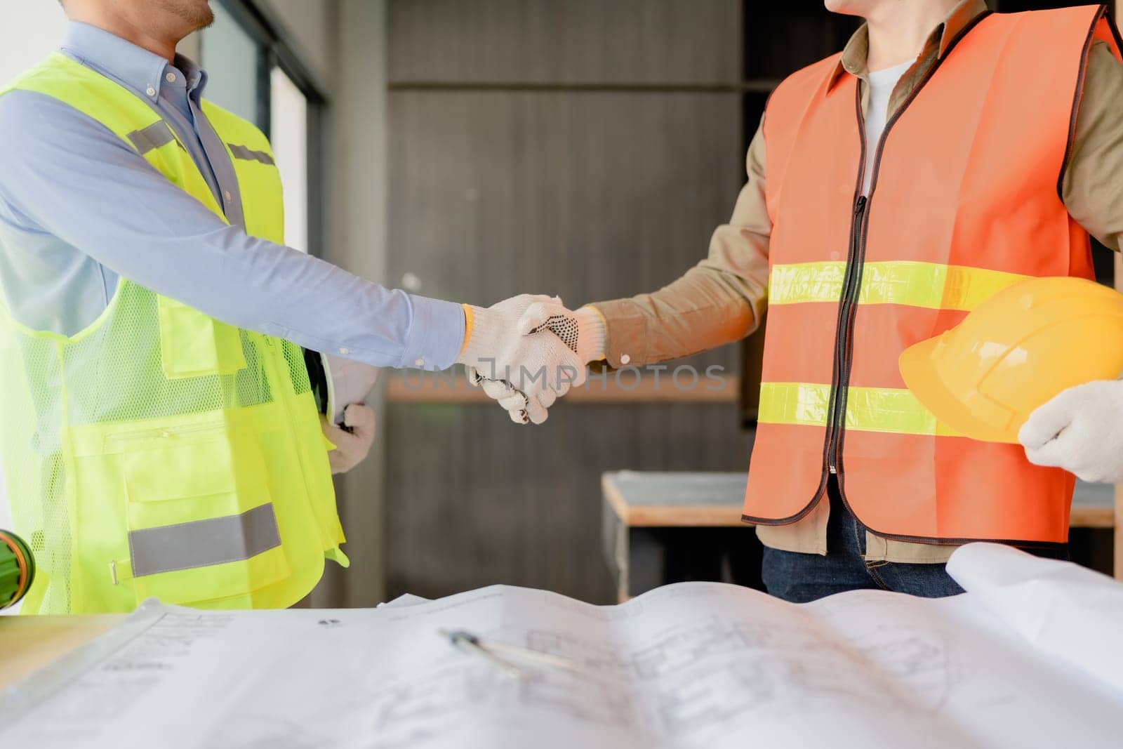 multi ethnic engineer brainstorming with deal and measuring for cost estimating on paperworks and floor plan drawings, contract and agreement concepts.