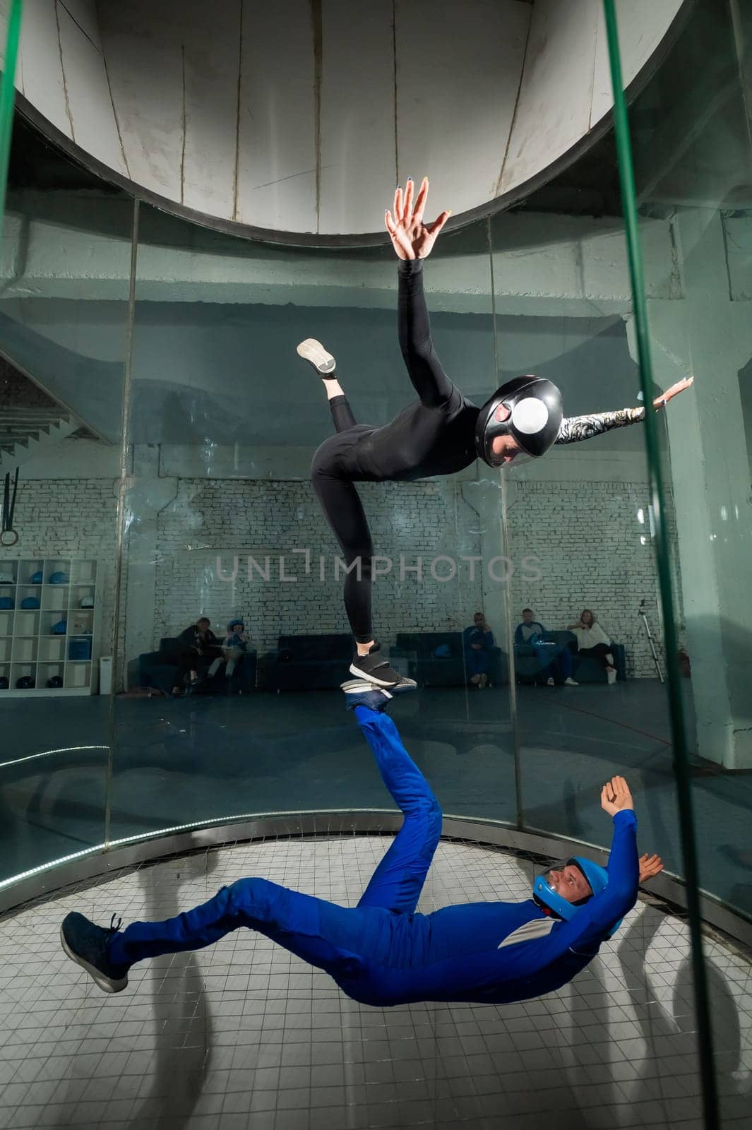 A man and a woman enjoy flying together in a wind tunnel. Free fall simulator.