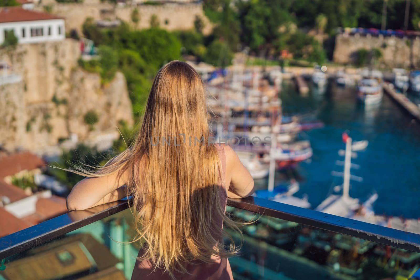Woman tourist in Old town Kaleici in Antalya. Turkiye. Panoramic view of Antalya Old Town port, Taurus mountains and Mediterrranean Sea, Turkey.