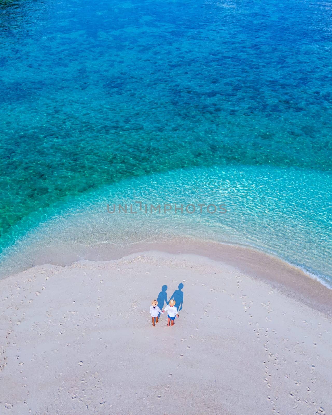 couple of men and women on the beach of Ko Lipe Island Thailand by fokkebok