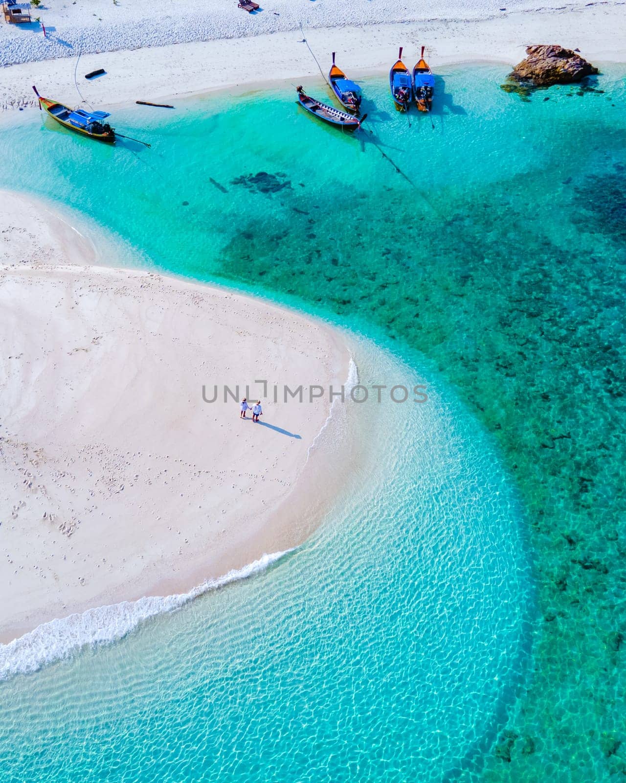 couple of men and women on the beach of Ko Lipe Island Thailand. drone aerial view of a sandbank in the ocean