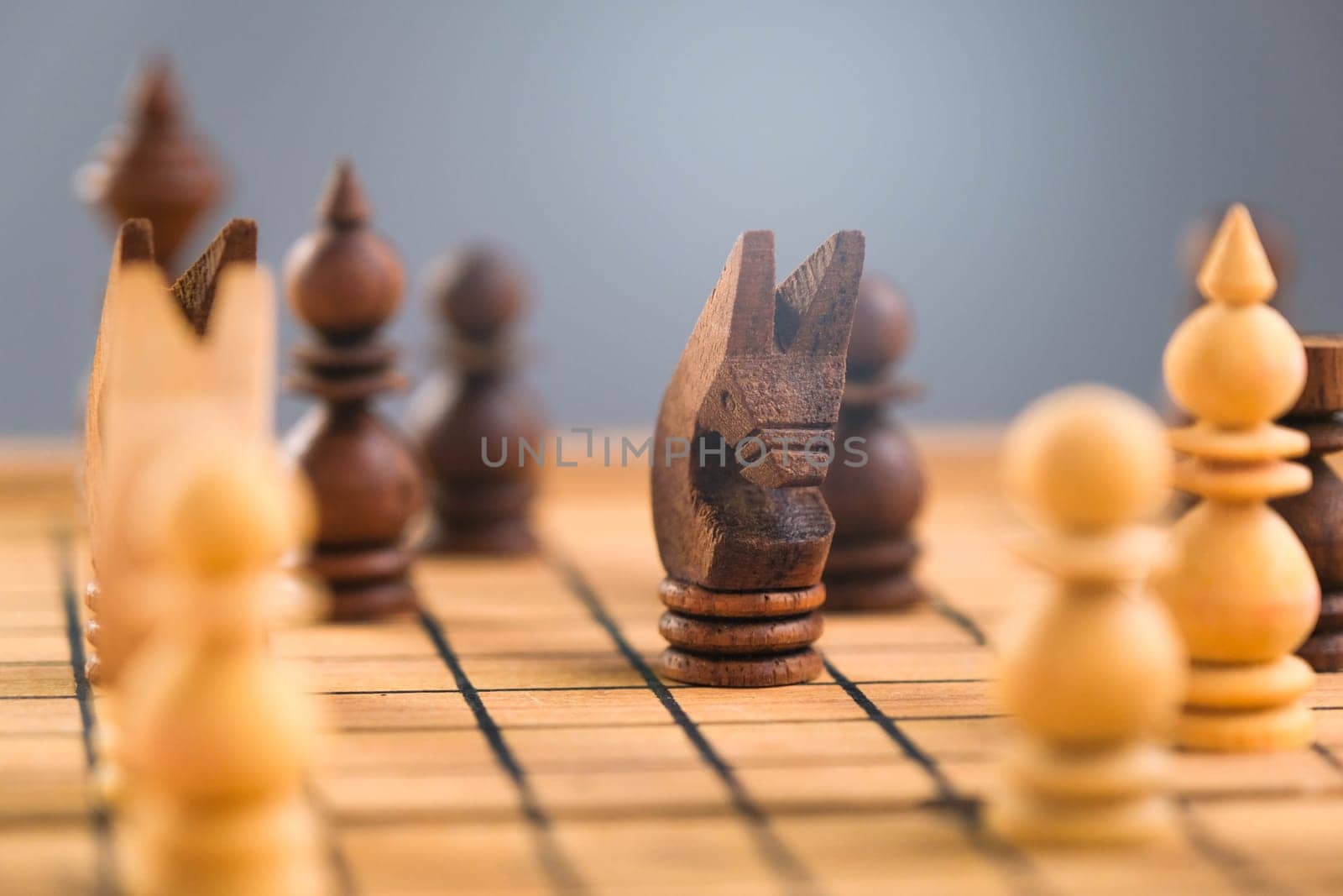 Close-up of businessman hands playing chess game. Concept of business strategy and tactic. by TEERASAK